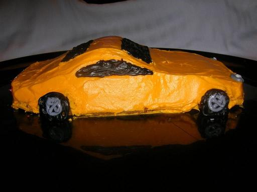 Car Cake.JPG - For a child's birthday or a 16th birthday, make a car cake. Press a layer of clay into the bottom of a bread pan. Shape the clay to be the inverse of the top of the car shape, such that the clay is predominately positioned towards the front and back of the pan. Pour in the cake batter, such that the clay is fully covered and add slightly more batter (about 1/2-inch more) is added; if too much more is added, the car will be too tall! Bake until done, loosen the cake from the sides of the pan, and invert the pan.Added by: Admin.